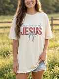 A woman wearing a vintage-style America Needs Jesus graphic t-shirt in a field, perfect for patriotic Christian apparel.