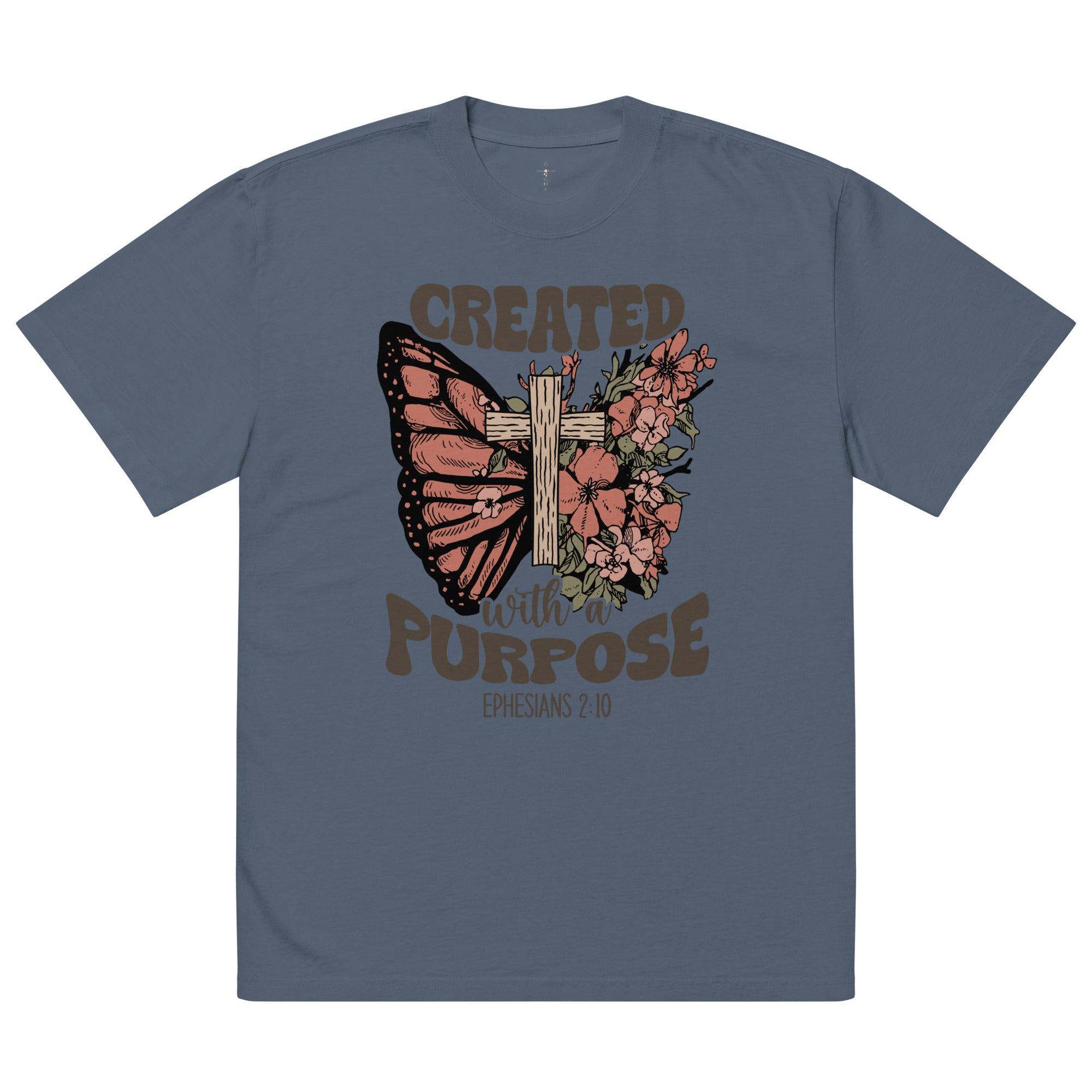 A blue oversized t-shirt featuring a Christian graphic design of a butterfly, a wooden cross, and flowers with the text Created With A Purpose and the Bible verse reference Ephesians 2:10.-indigo.