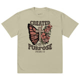 An isolated product view of a tan, faded, boho-style Christian t-shirt featuring a floral cross, butterfly, and the bible verse Ephesians 2:10