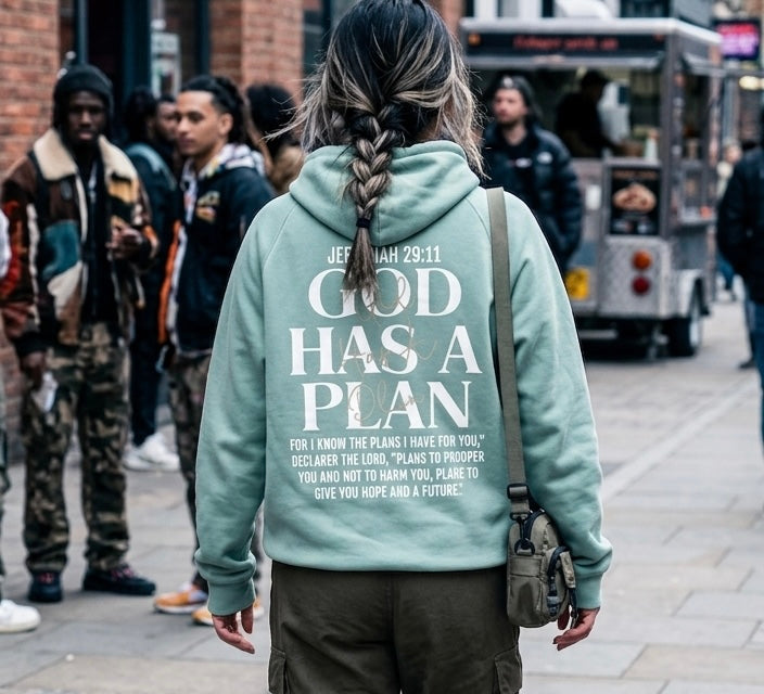 Back view of a person wearing a sage green Christian hoodie featuring the inspirational "God Has A Plan" scripture design, ideal for intentional and modest streetwear