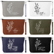 A collection of six Christian faith-based canvas makeup bags in grey, white, brown, olive green, navy blue, and black, each featuring white botanical line art, a unique scripture verse quote, and a matching wristlet strap.