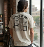 Man wearing a cream unisex Christian streetwear t-shirt showcasing a detailed "God is Good all the time" graphic on the back