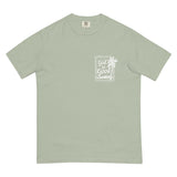 Flat lay of a sage green faith-based graphic tee featuring a minimalist "God is Good" palm tree stamp on the chest.
