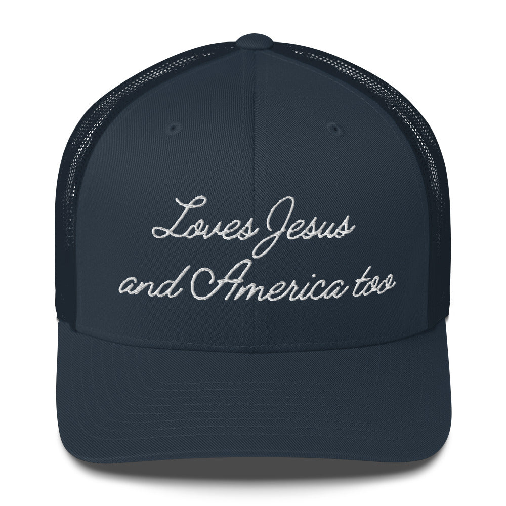 Front view of a solid navy blue faith-inspired trucker hat featuring the embroidered slogan Loves Jesus and America too.