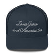 Front view of a solid navy blue faith-inspired trucker hat featuring the embroidered slogan Loves Jesus and America too.
