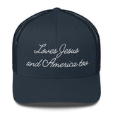 Front view of a solid navy blue faith-inspired trucker hat featuring the embroidered slogan Loves Jesus and America too.