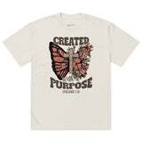 An isolated product view of a cream oversized faded t-shirt with a Christian graphic showing a butterfly, cross, and the quote Created With A Purpose