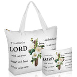 A studio product photograph featuring a white tote bag and a matching smaller zippered pouch, both printed with a floral cross design and the Bible verse Proverbs 3:5-6, "Trust in the LORD with all your heart and lean not on your own understanding
