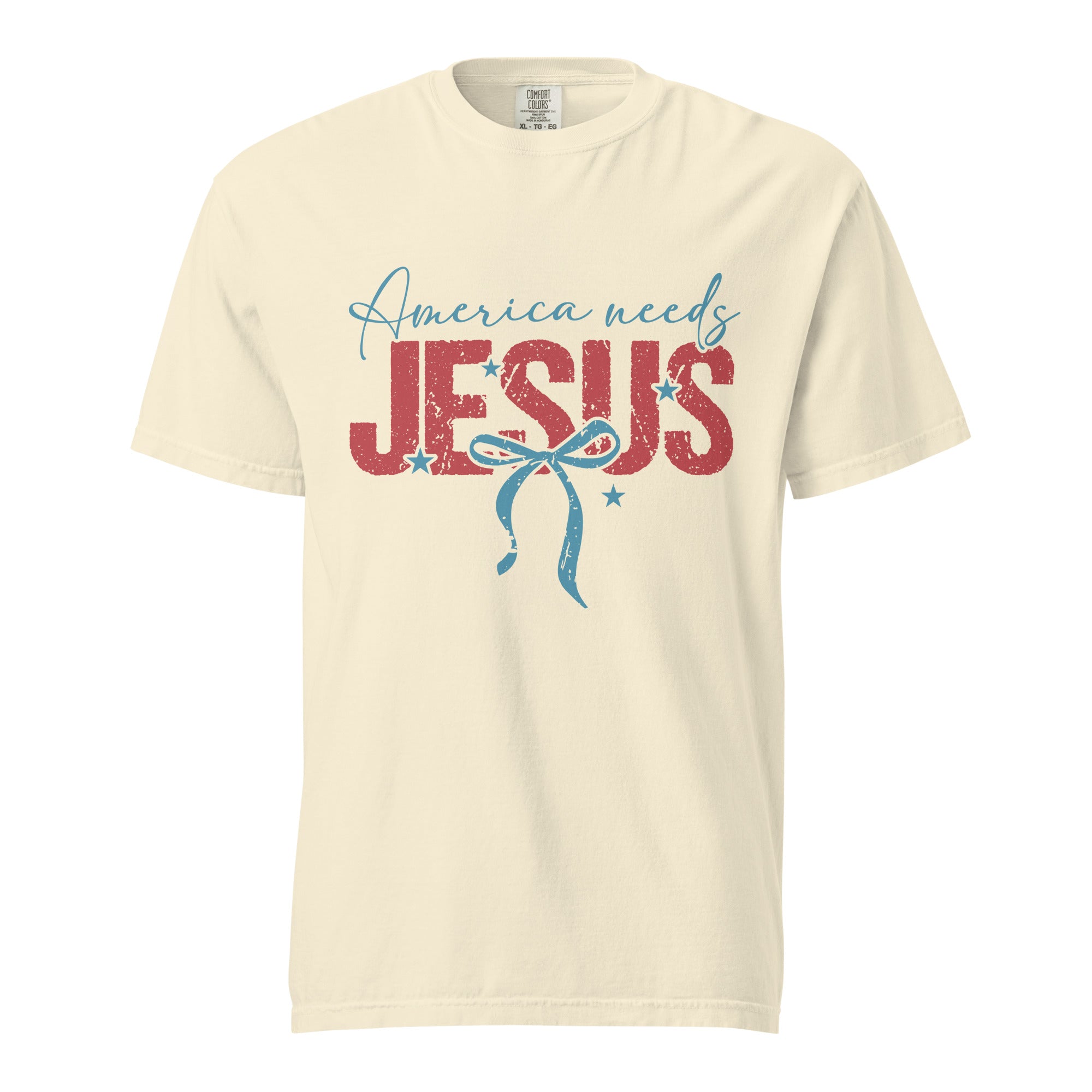 A front view of a cream-colored unisex heavyweight garment-dyed t-shirt featuring the America Needs Jesus graphic design