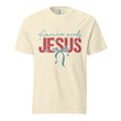 A front view of a cream-colored unisex heavyweight garment-dyed t-shirt featuring the America Needs Jesus graphic design