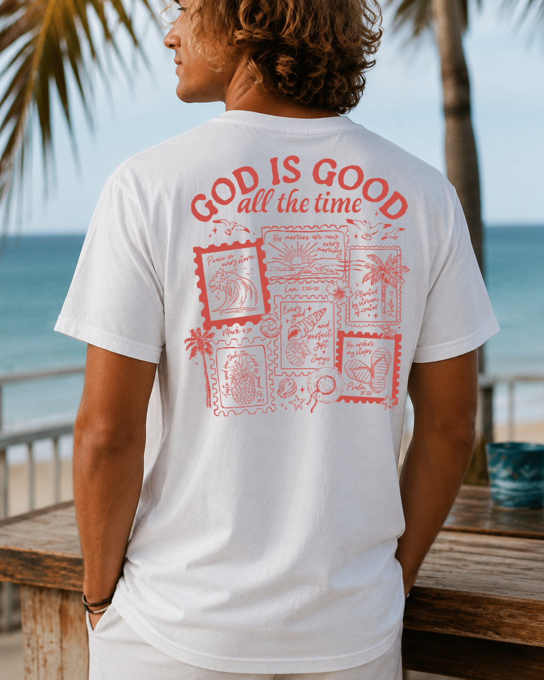 Back view of a man wearing a white inspirational Christian t-shirt featuring a "God is Good all the time" stamp-style graphic design