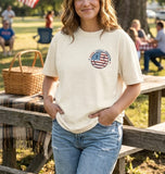 A young woman wearing a cream-colored Faith, Family, and Freedom t-shirt smiling at an outdoor Christian family picnic